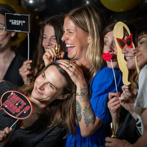 Past winner Jaime Moar, is photographed with Team Members enjoying the photo booth with props at the 2025 Quebec Grand Finale, Place Viger Montreal.
